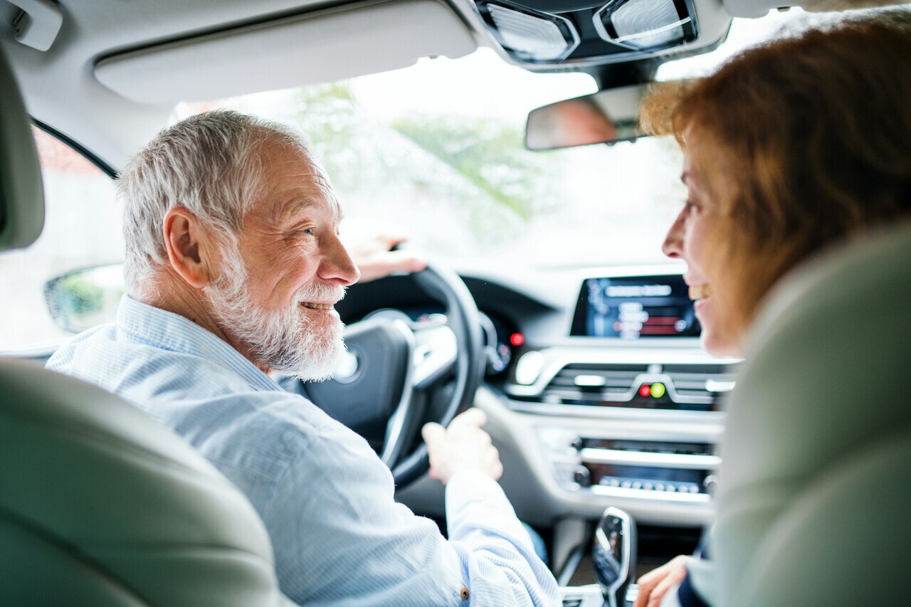 elderly man driving / in transportation